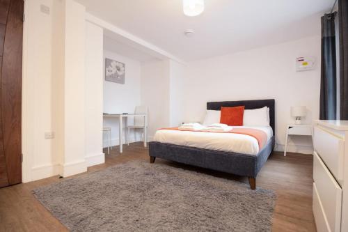 Un dormitorio con una cama y una alfombra. en SAV Apartments Regent Leicester, en Leicester