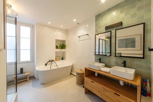 Grande maison chaleureuse Angers في أنجيه: حمام مع حوض ومغسلة وحوض استحمام