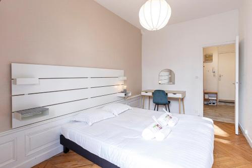 um quarto com uma grande cama branca e uma secretária em Le Saint-Aubin appartement chic et moderne em Angers