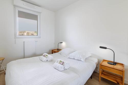 sypialnia z 2 łóżkami z białą pościelą i oknem w obiekcie Bel appartement moderne avec jardin w mieście Angers