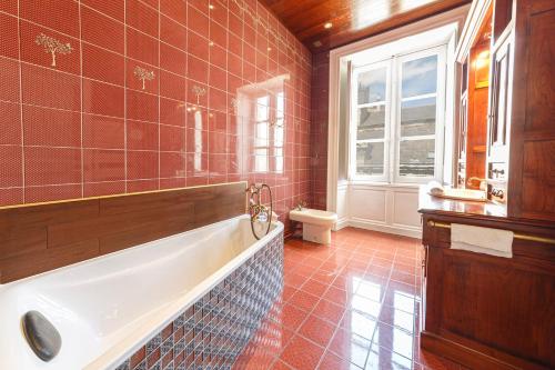 a bathroom with a tub and a toilet and a window at Le Roi René appartement Haussmannien in Angers