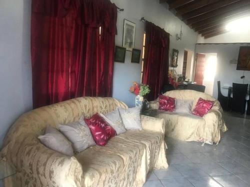 a living room with a couch and a red curtain at Cozy 2BR/1BA retreat in St.Kitts close to airport in Romneys