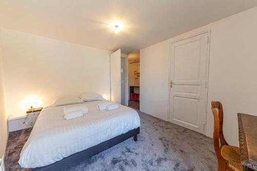 a bedroom with a large white bed with two pillows at Loire-side house near Angers in Bouchemaine