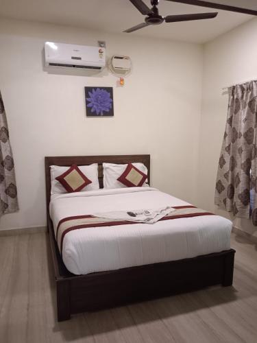 a bedroom with a bed and a ceiling fan at Iris Comfort Inn in Chennai
