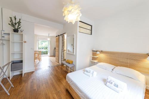 - une chambre avec un lit blanc et une salle à manger dans l'établissement Le Morphée - Appartement avec jardin, à Angers