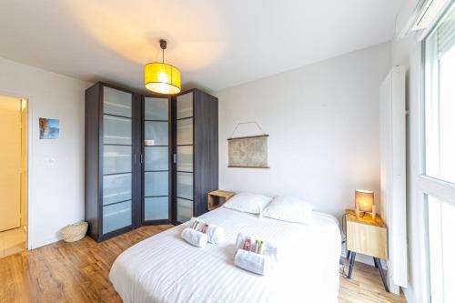 a bedroom with two beds and a window at Le Jean Moulin - Appartement à 2 pas du tramway in Angers