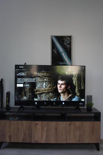 a flat screen tv sitting on top of a wooden entertainment center at Milan's Apartment in Skopje