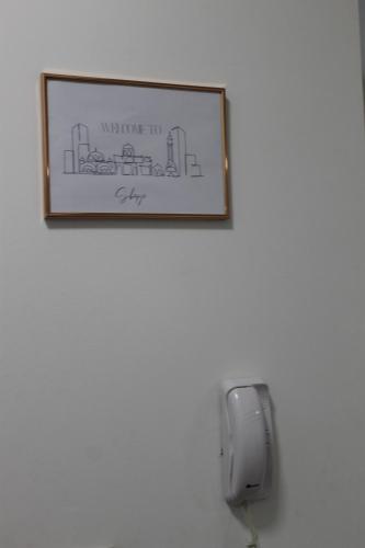 a picture hanging on a wall with a phone at Milan's Apartment in Skopje