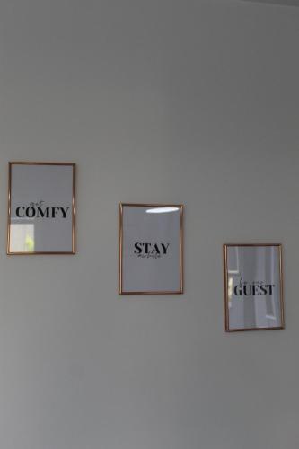 four pictures on a wall with the words worry worry stay and distrust at Milan's Apartment in Skopje