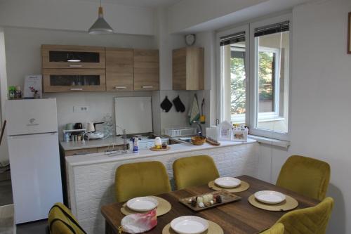a kitchen with a table and chairs and a kitchen with a refrigerator at Milan's Apartment in Skopje