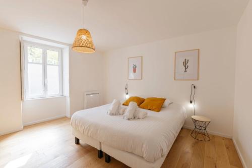 - une chambre blanche avec un lit et 2 serviettes dans l'établissement LE TOPAZE - Appartement T4 Angers centre, à Angers