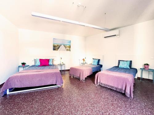 two beds in a room with pink and blue at By Cathedral Rooms in Barcelona