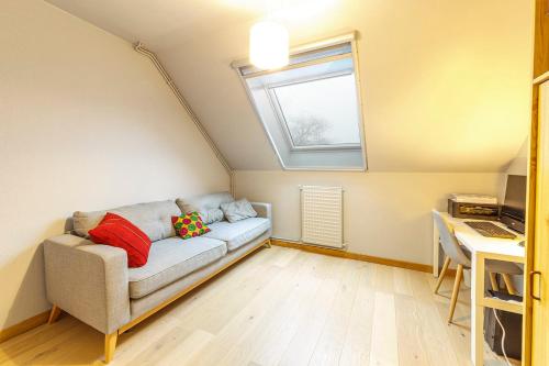 uma sala de estar com um sofá e uma janela em Maison familiale avec jardin et garage em Beaucouzé
