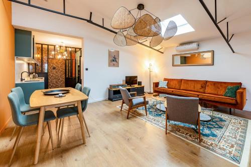 a living room with a table and chairs and a couch at Appartement vintage - Proche centre in Angers