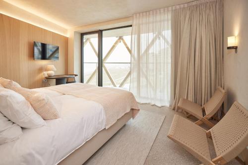 a bedroom with a bed and a large window at C-Hotels Silt in Middelkerke