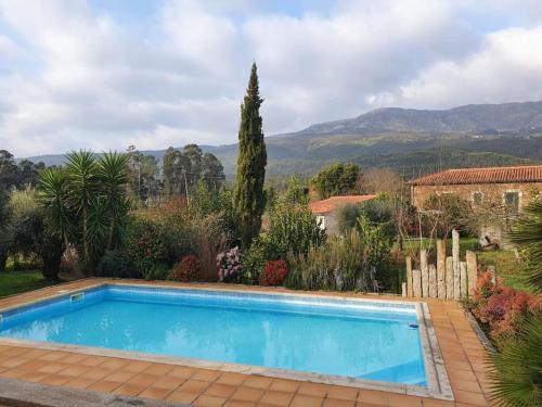 een zwembad in een tuin met bergen op de achtergrond bij PONTE DE LIMA - VILLA VIVENDA OLIVAL - Piscine privée entre mer et montagne in Canadelo