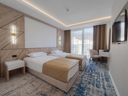 a hotel room with two beds and a television at Hotel Tara Becici in Budva
