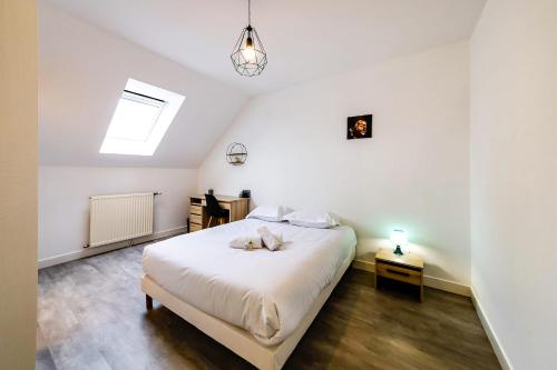 - une chambre avec un lit blanc et une lucarne dans l'établissement Le Soleil Levant - T6 proche centre, à Angers