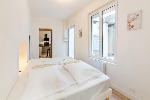 a white bed in a white room with a window at L'Ydille - Jolie T2 en hyper centre in Angers