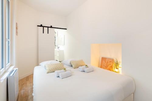 a white bedroom with a large white bed with pillows at L'Ydille - Jolie T2 en hyper centre in Angers