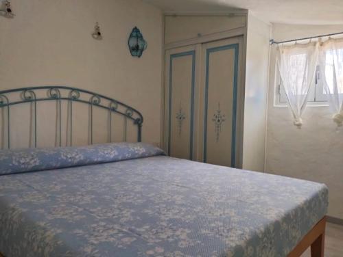 a bedroom with a bed and a window and a door at Villetta Luna in San Teodoro