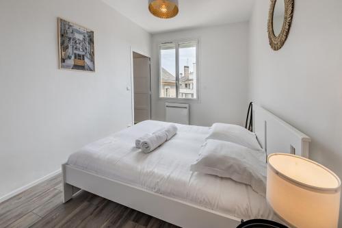 - une chambre avec un lit doté de draps blancs et une fenêtre dans l'établissement Le Quartz - Appartement coquet gare, à Angers