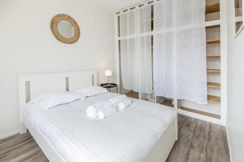 - une chambre blanche dotée d'un lit avec des draps et des oreillers blancs dans l'établissement Le Quartz - Appartement coquet gare, à Angers