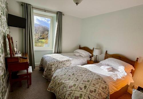 um quarto de hotel com duas camas e uma janela em Forest How Guest House em Eskdale