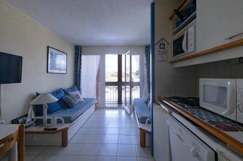una pequeña sala de estar con sofá y microondas en Joli studio sur le Port du Crouesty, en Arzon