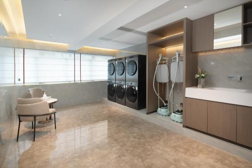 a laundry room with a row of washing machines at Yizhi Hotel - Guangzhou Beijing Road Chenjiaxuan Subway Station in Guangzhou