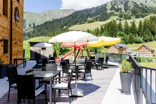 a patio with tables and chairs and umbrellas at Lisas Schröcken in Schröcken