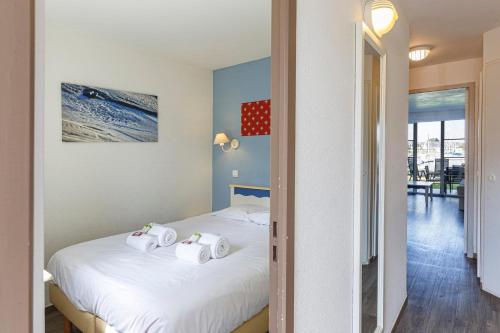 a bedroom with a bed with towels on it at Charmant appartement vue sur le Crouesty in Arzon