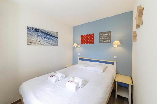 a bedroom with a bed with two towels on it at Charmant appartement vue sur le Crouesty in Arzon