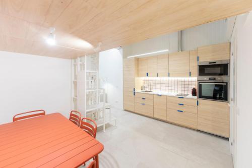 a kitchen with wooden cabinets and a table with chairs at Cozy Triplex en Malasaña in Madrid