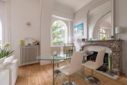 een woonkamer met een glazen tafel en een open haard bij LE PRESTIGE - Bel appartement face mer in La Baule
