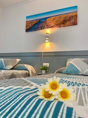 a bedroom with two beds with flowers on the bed at Hostal Los Mellizos in Conil de la Frontera