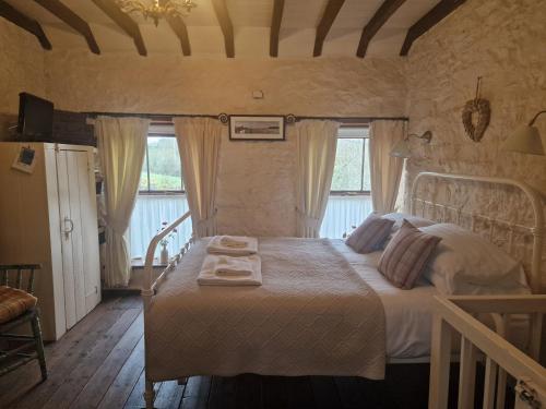 a bedroom with a bed with two towels on it at Bryn-y-Gof in Llwyn-Dafydd