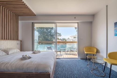 a bedroom with a bed and a view of a balcony at LE DESIGN - Appartement vers la gare in La Baule