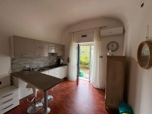 uma cozinha com uma mesa e um relógio na parede em La Spezia La Perla dei Poeti em Vezzano Ligure
