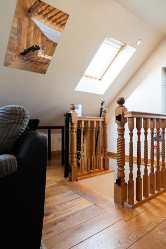 a living room with a skylight and wooden stairs at Silverwood Loft in Telford