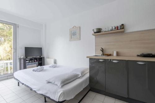 - une cuisine avec un lit dans une chambre dans l'établissement LES PETRELS - Appartement rez-de-jardin, à Pornichet