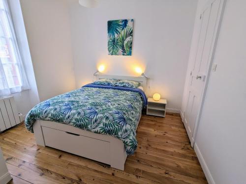 1 dormitorio con 1 cama con edredón azul y blanco en T2 42 m² en Centre-ville de Cambo-les-Bains, en Cambo-les-Bains