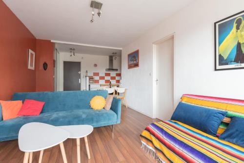 - un salon avec un canapé bleu et une table dans l'établissement Appartement à 200m de ThalassoSpa, à Pornic