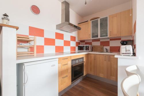 - une petite cuisine avec des armoires et des appareils en bois dans l'établissement Appartement à 200m de ThalassoSpa, à Pornic