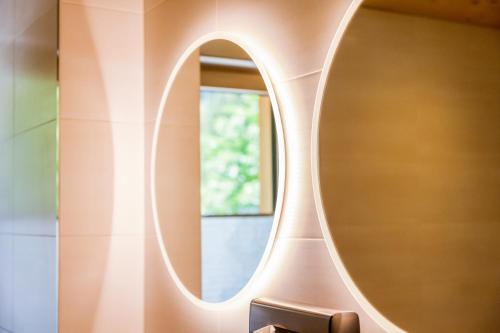 a bathroom with a round mirror on a wall at Lisas Schröcken in Schröcken
