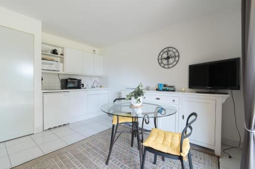 Appartement avec Golf tennis et mer في بورنيك: مطبخ مع طاولة زجاجية وتلفزيون