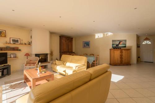 ein Wohnzimmer mit einem Sofa und einem Tisch in der Unterkunft Maison plain pied proche plage in Préfailles