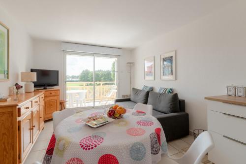 ein Wohnzimmer mit einem Tisch und einem Sofa in der Unterkunft Appartement vue sur Golf de Pornic in Pornic