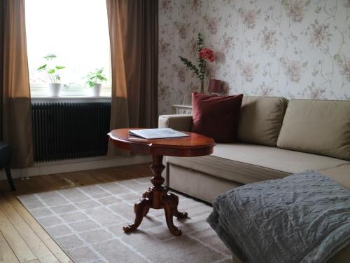 a living room with a table and a couch at Lustigsgården Boutique Hotel in Rättvik