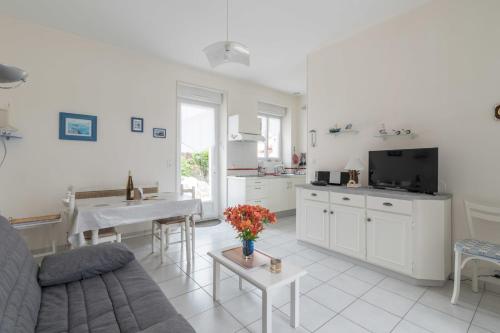 een keuken en een woonkamer met een bank en een tafel bij Birochère Maison lumineuse avec jardin in Pornic